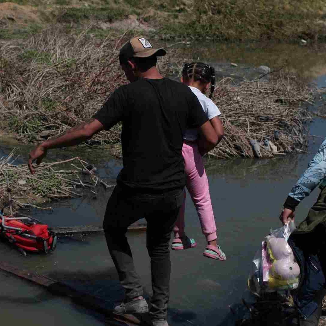 Migrantes cruzan por el río Bravo.