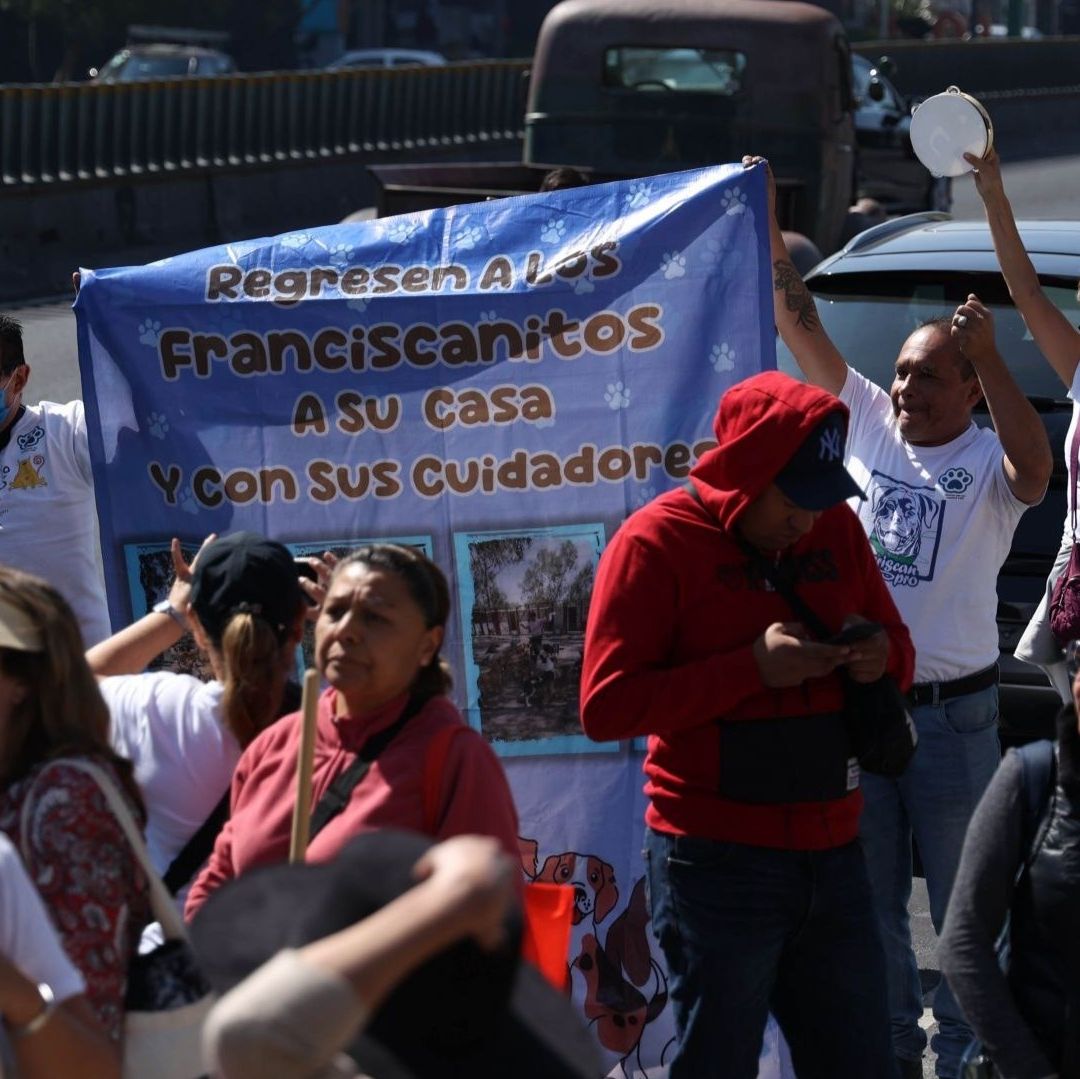 Personas protestan llevan un cártel.