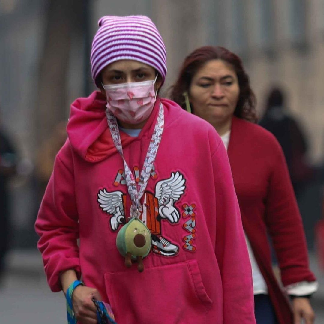 Una mujer se protege de las bajas temperaturas en la plancha del Zócalo en diciembre 2025. Foto: Cuartoscuro