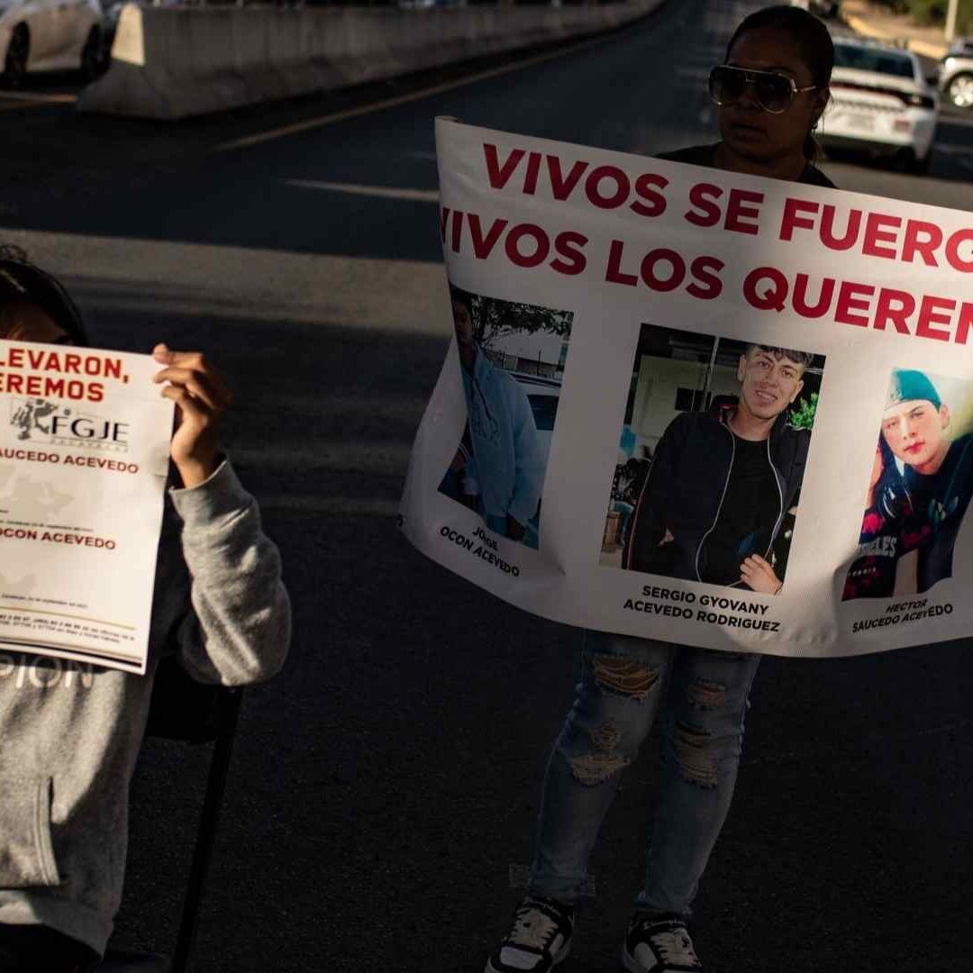 Familiares portan cárteles con las fichas de búsqueda de los jóvenes