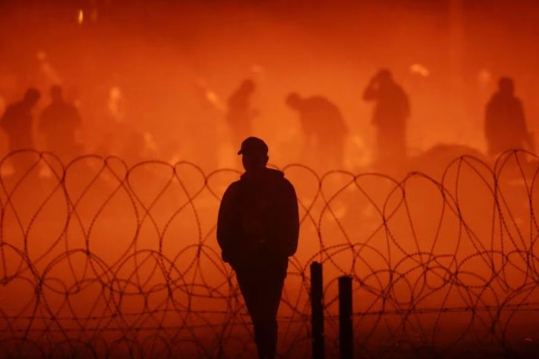 Migrantes se reúnen cerca del muro fronterizo después de cruzar el río Bravo