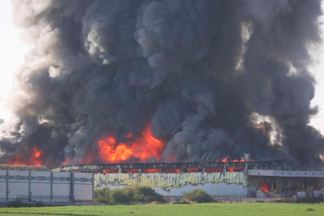 Gran incendio y columna de humo negro emergiendo de un edificio, resultado de un ataque en el contexto del conflicto entre Israel y Palestina.