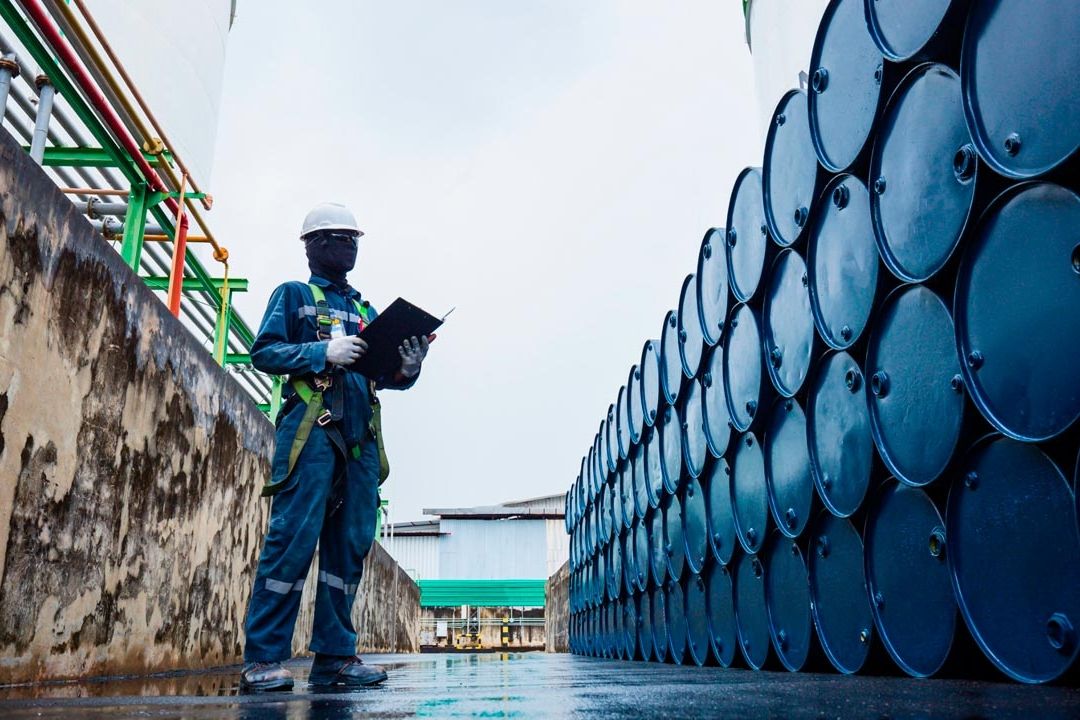 Trabajador inspeccionando barriles de petróleo