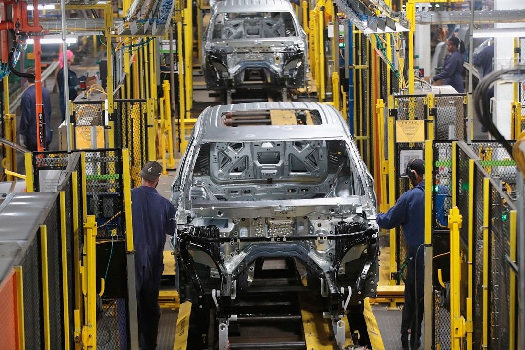 Operarios trabajando en una moderna línea de ensamblaje en la industria automotriz mexicana