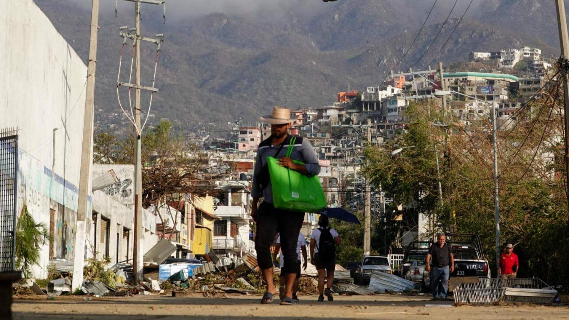 Pobladores recorren calles de Acapulco tras paso del huracán Otis.