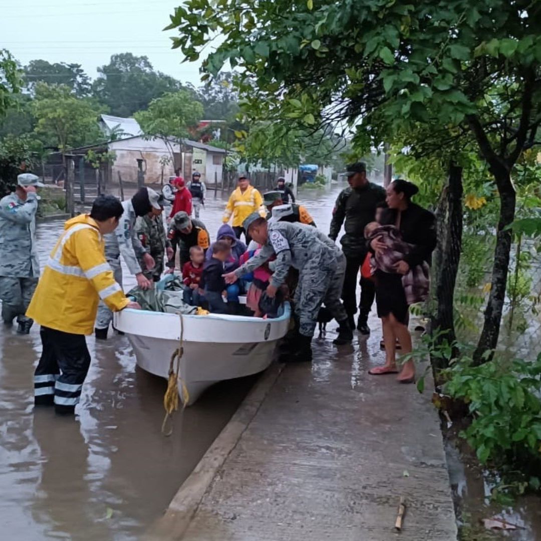 Guardias nacionales ayudan a evacuar a población afectada por inundaciones.