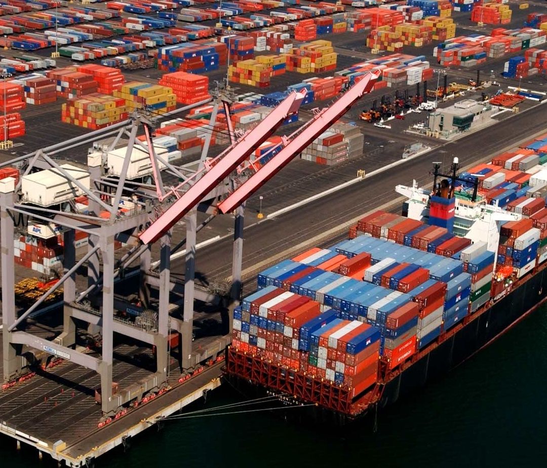 Puerto con grúas cargando buque de contenedores.