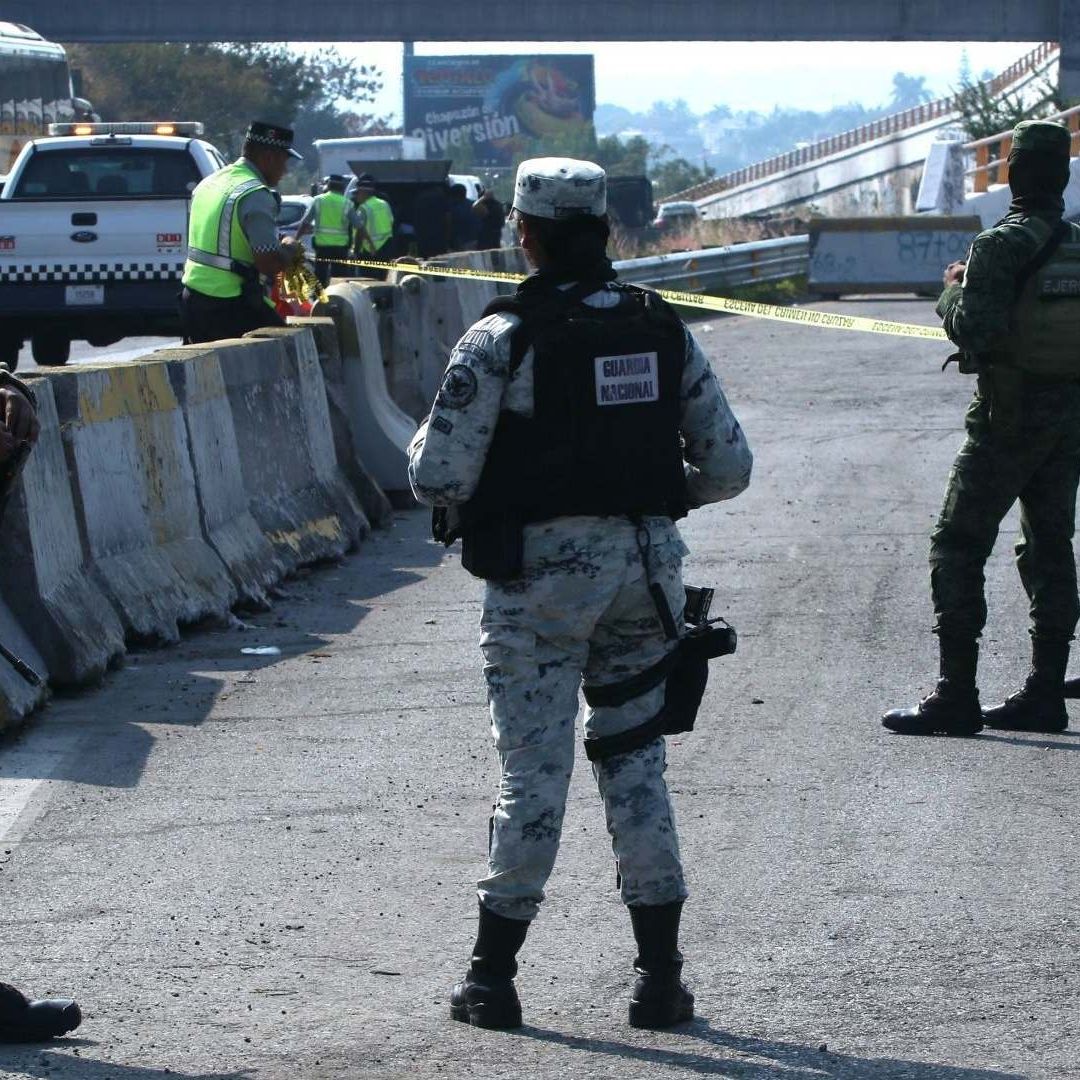 Elementos de la Guardia Nacional y del Ejercito realizan labores de acordonamiento de una escena de crimen en la autopista del Sol