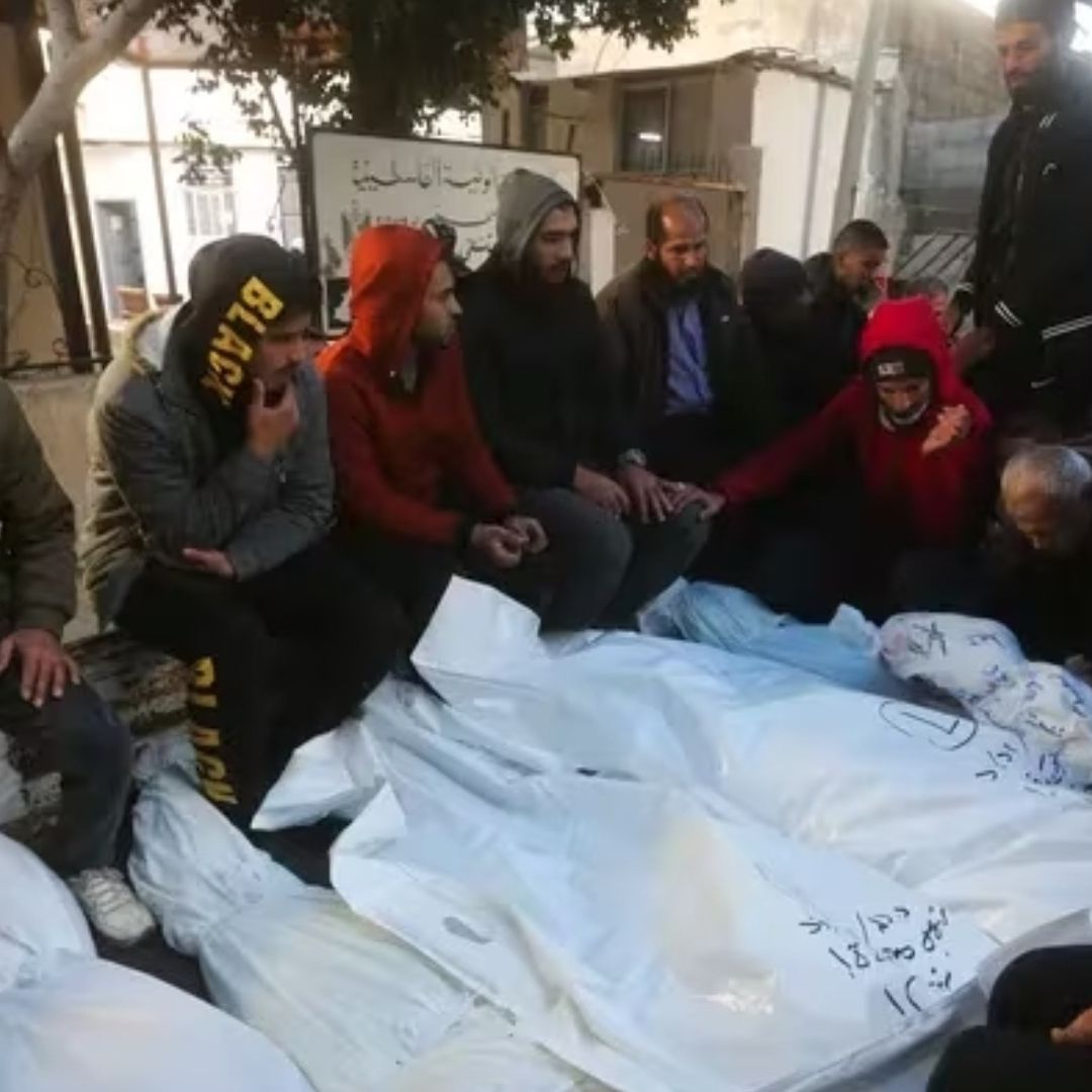 Palestinos se sientan junto a los cuerpos de familiares muertos en la Guerra contra Israel