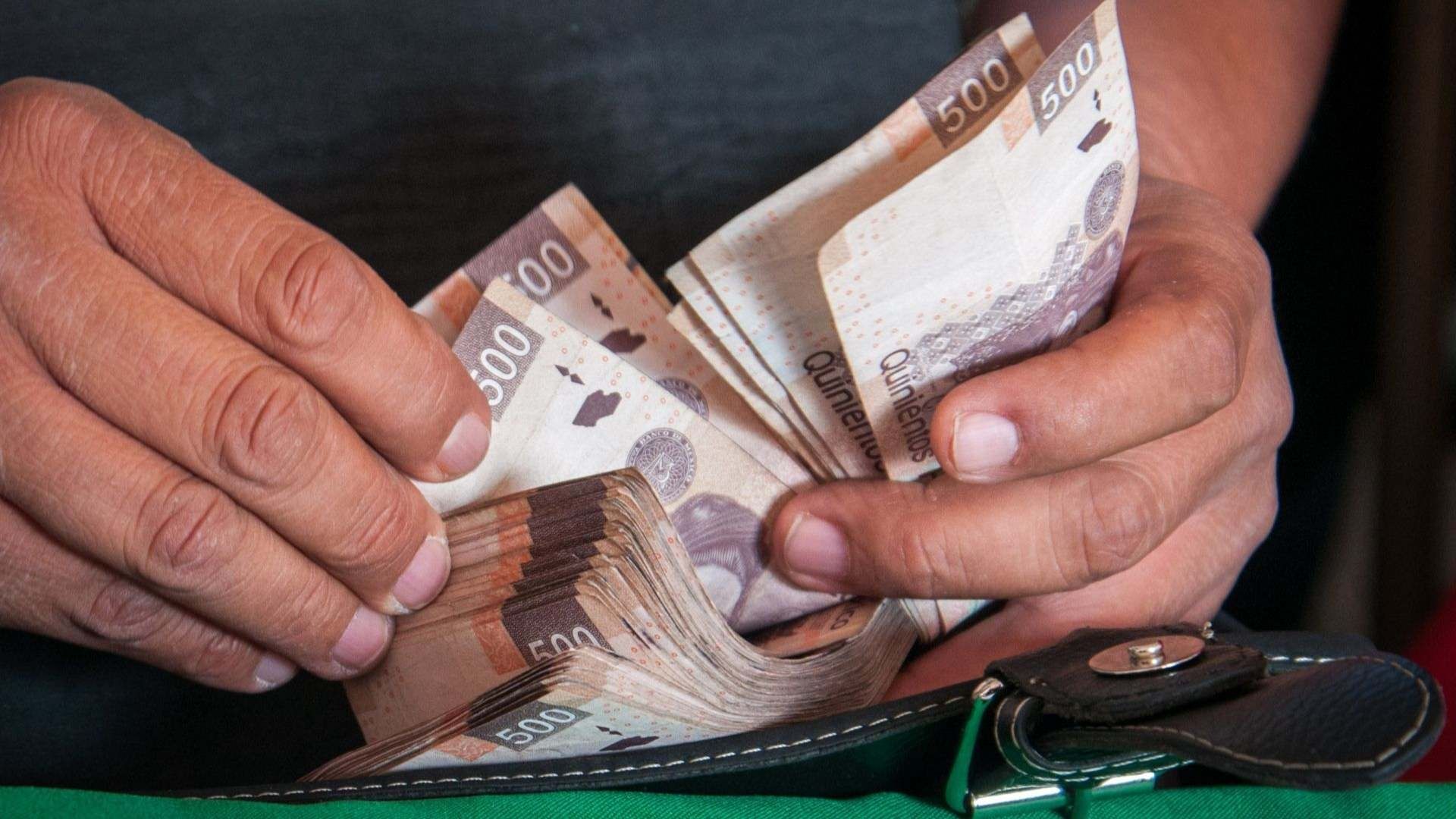 Una persona cuenta dinero en efectivo