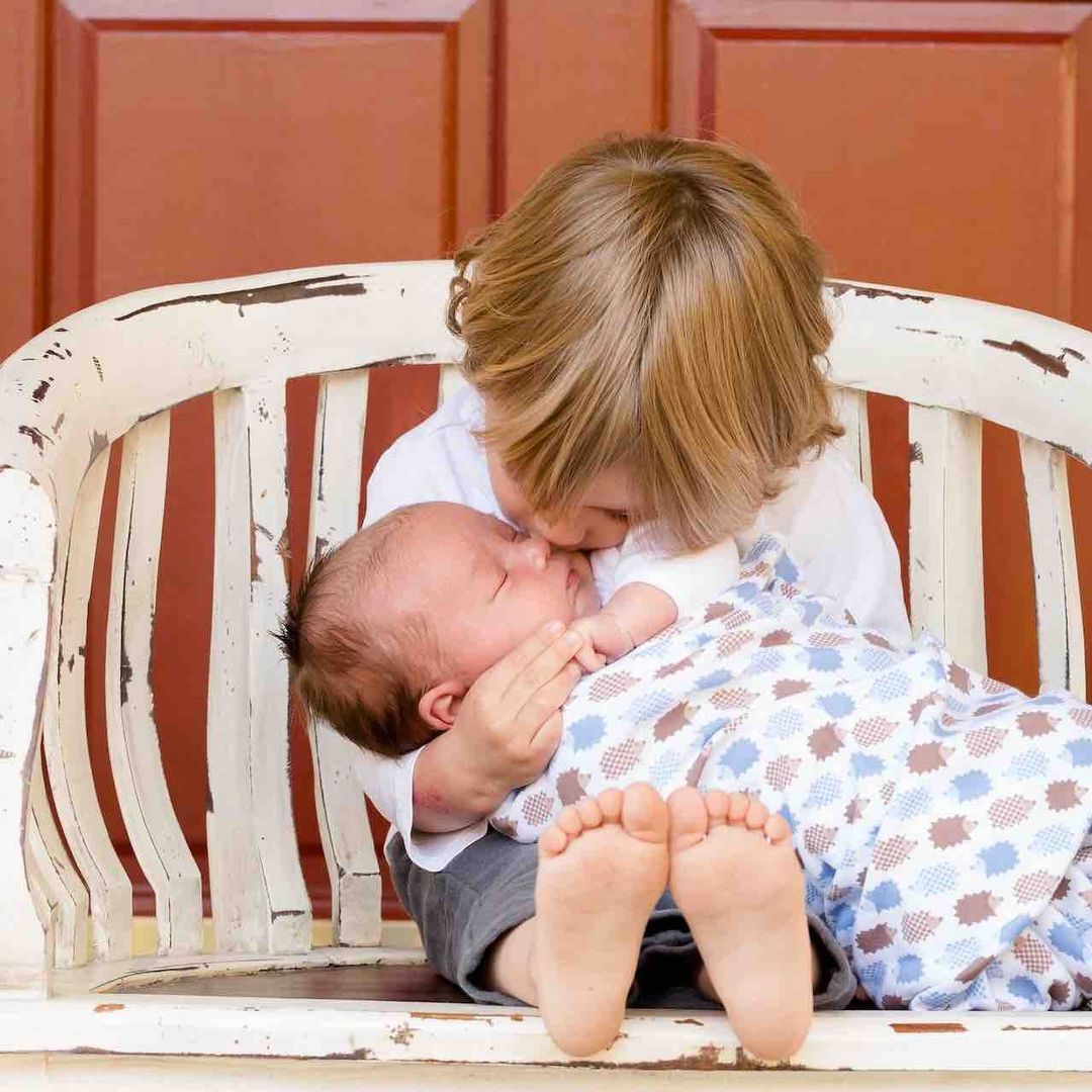 Niño sostiene a un bebé recién nacido