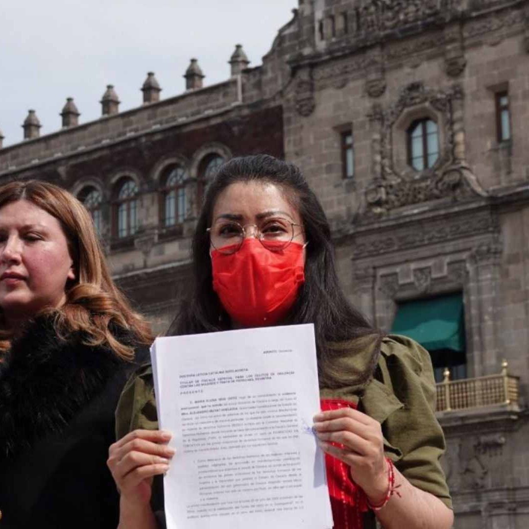 La saxofonista oaxaqueña, María Elena Ríos, muestra la denuncia en el Zócalo