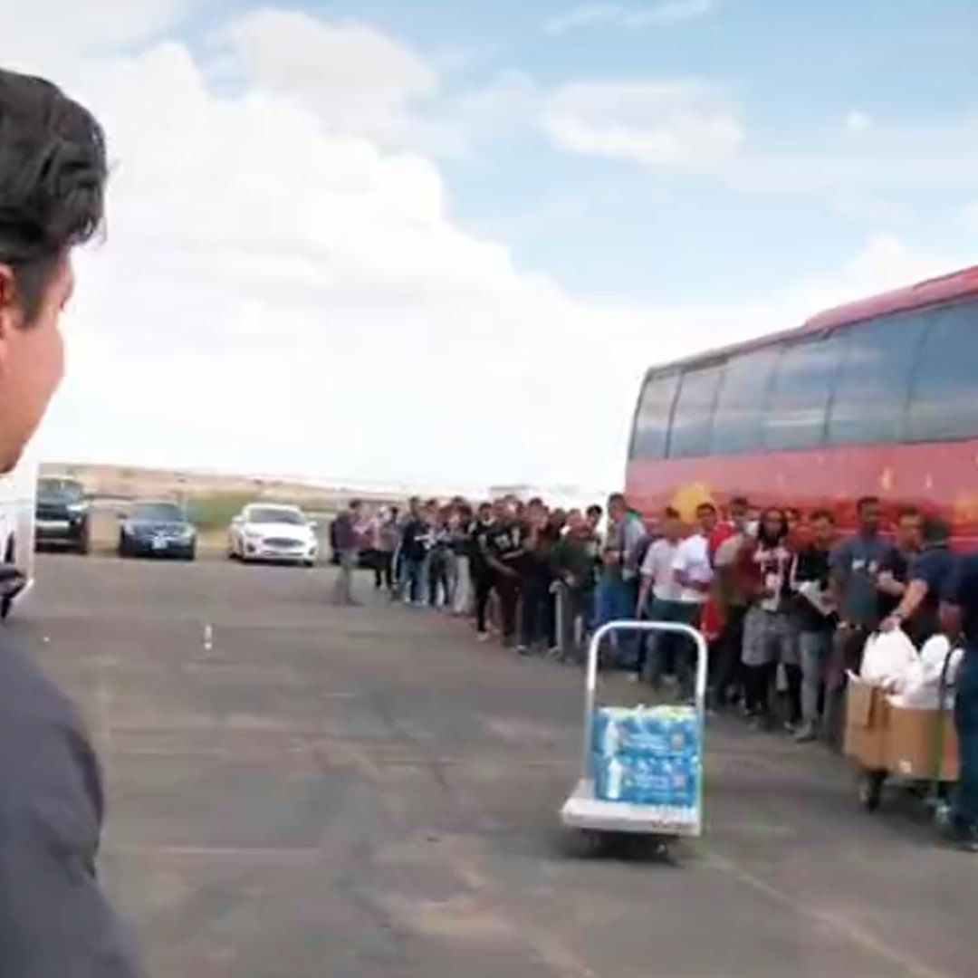 Migrantes esperan para subir a un autobús en El Paso, Texas