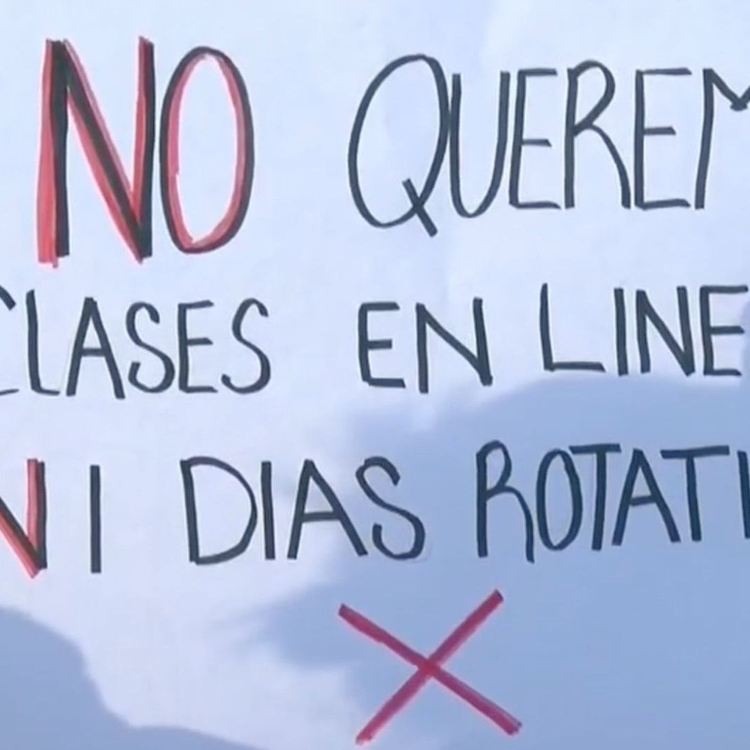 Pancarta de manifestante que dice "no queremos clases en línea, ni días rotativos"