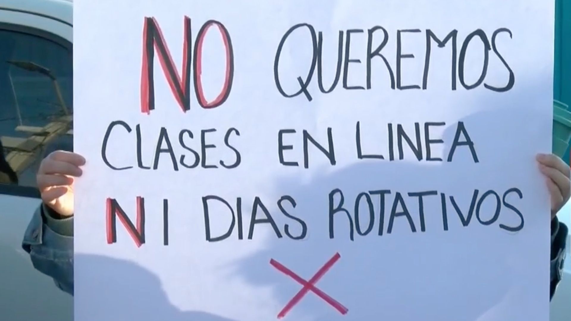 Pancarta de manifestante que dice "no queremos clases en línea, ni días rotativos"