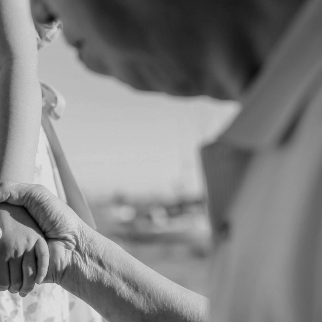 Abuelo toma de la mano a niña con vestido
