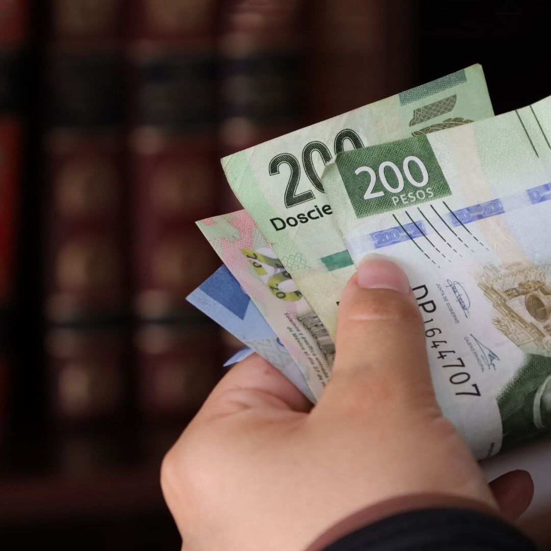 Mano sujetando un fajo de billetes