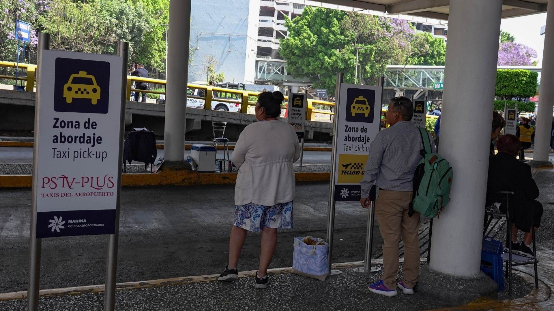 Personas esperan en el AICM.
