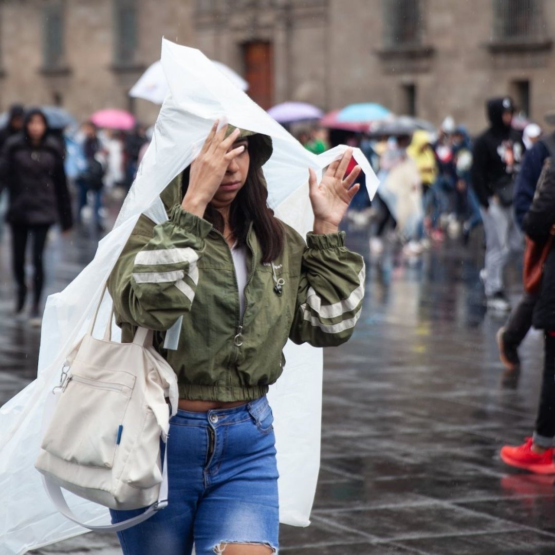 Personas se protegen de la lluvia en la Ciudad de México