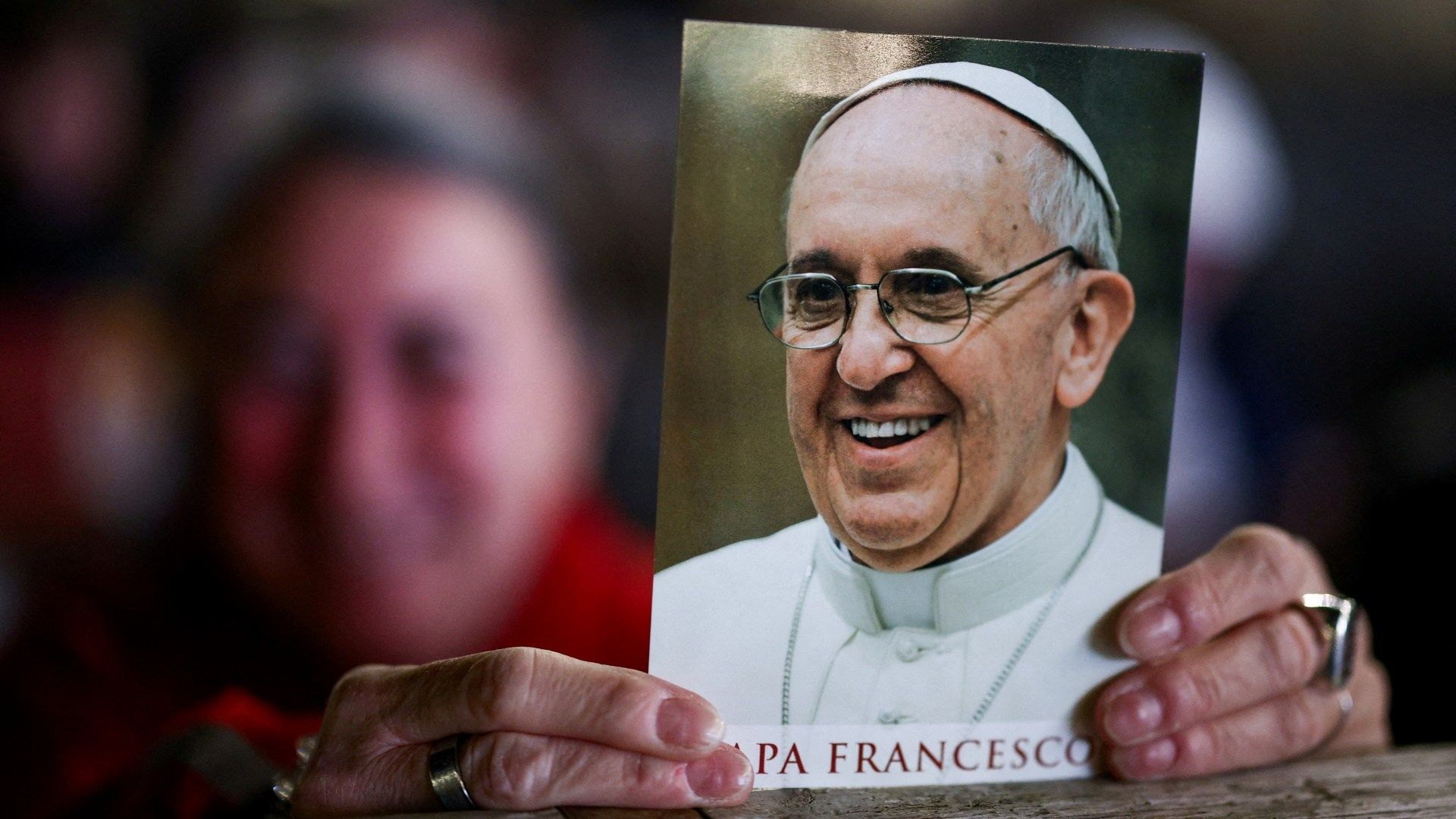 Mujer sostiene una imagen del papa Francisco en la Plaza de San Pedro