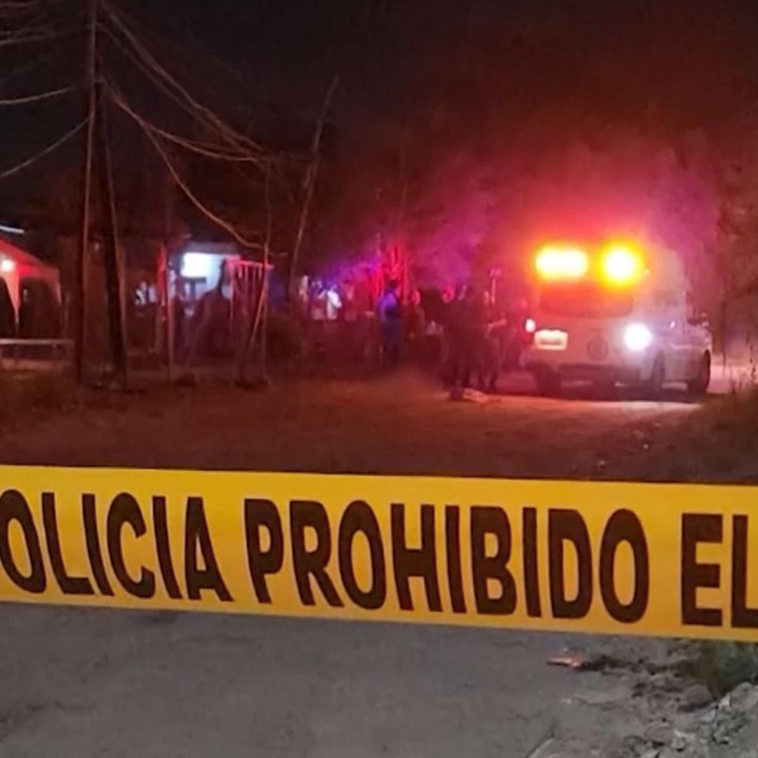 Ambulancia junto a elementos de seguridad revisando un cuerpo en Sinaloa