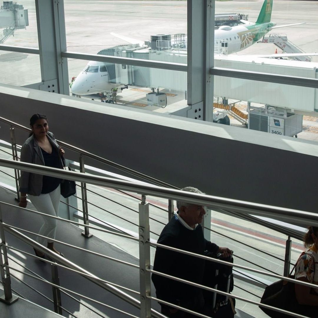 Cuatro personas caminan por el aeropuerto.