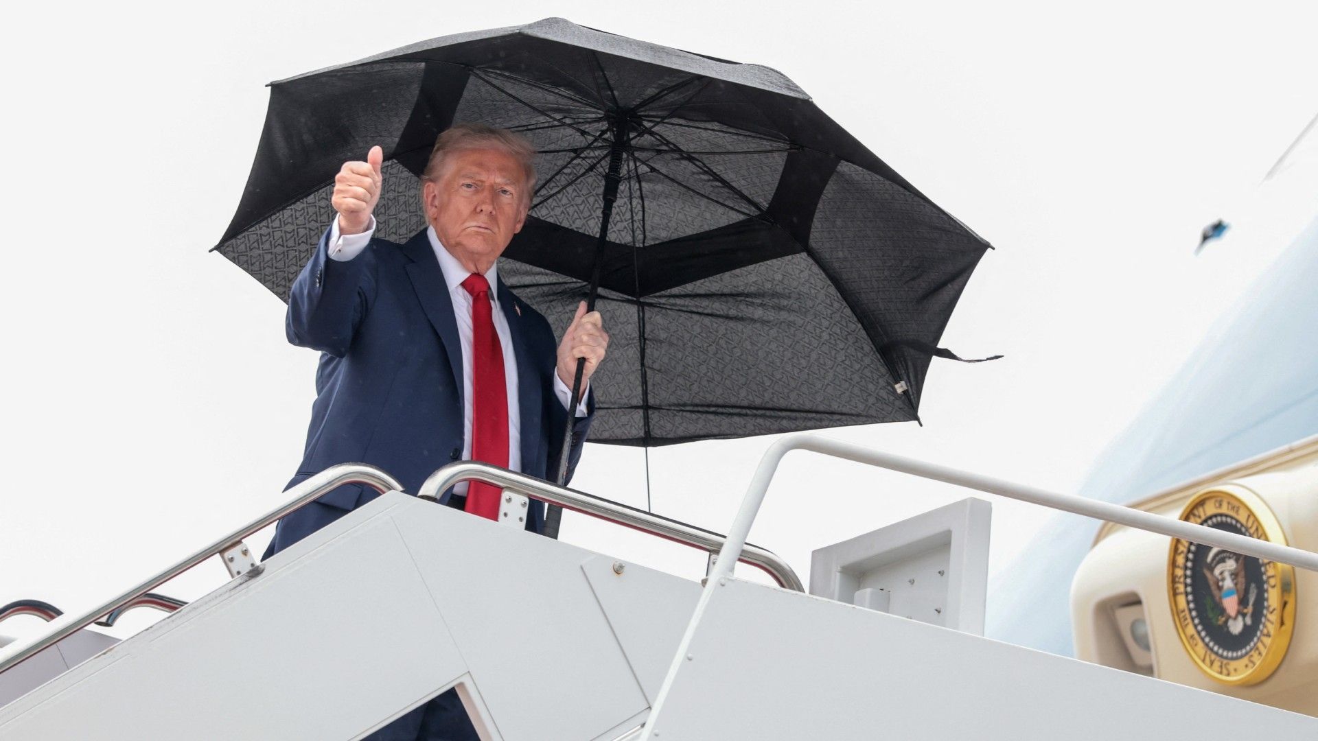 Donald Trump aluda a la cámara, al subir al Air Force One para viajar a Israel.