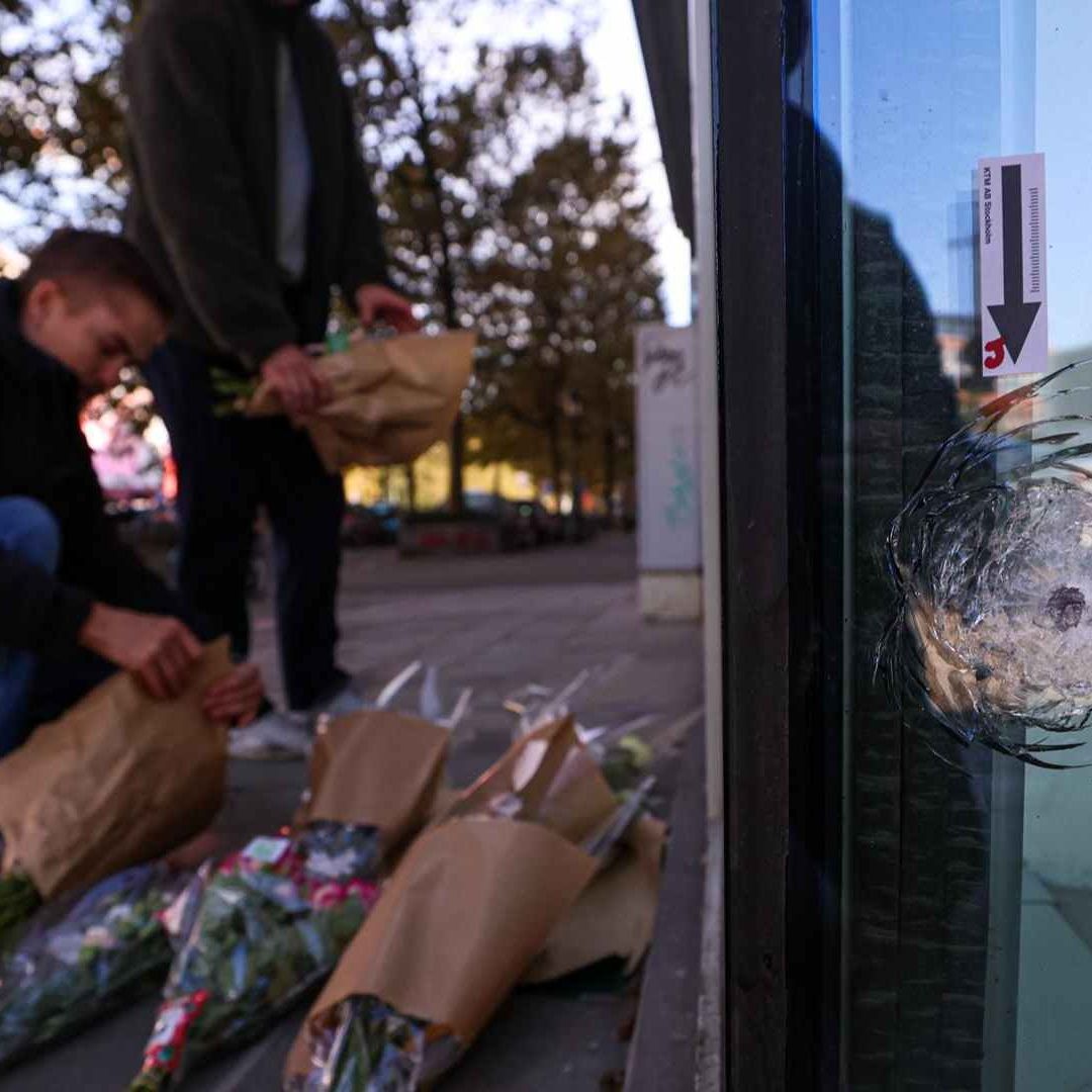 Personas colocaron flores junto a la sucursal bancaria donde aficionados de la selección de Suecia fueron ejecutados en Bruselas. Foto: EFE