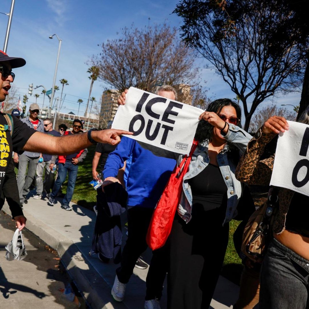 Manifestantes sacan toallas con la leyenda ICE Out en el Super Bowl.