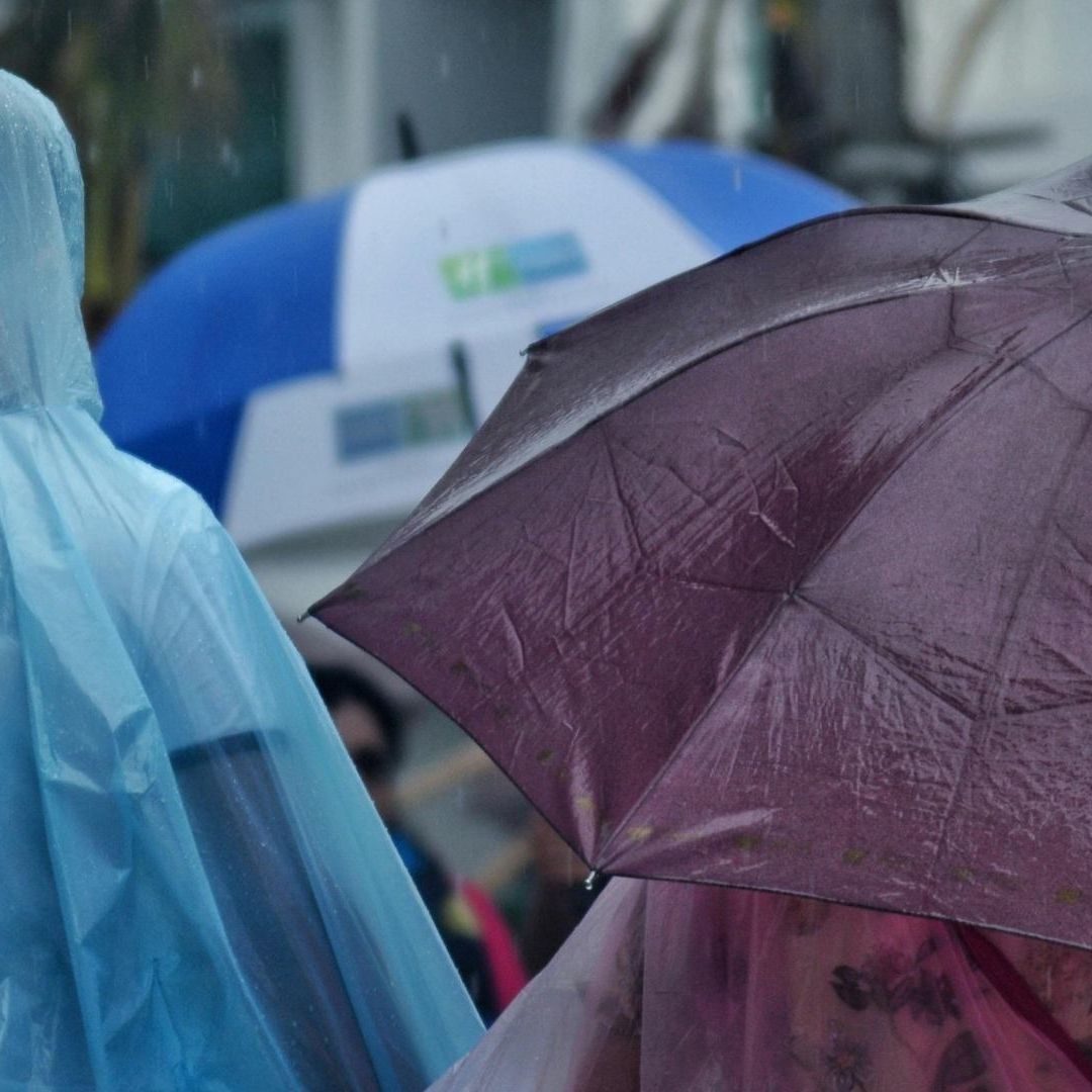 Persona con impermeable y paraguas