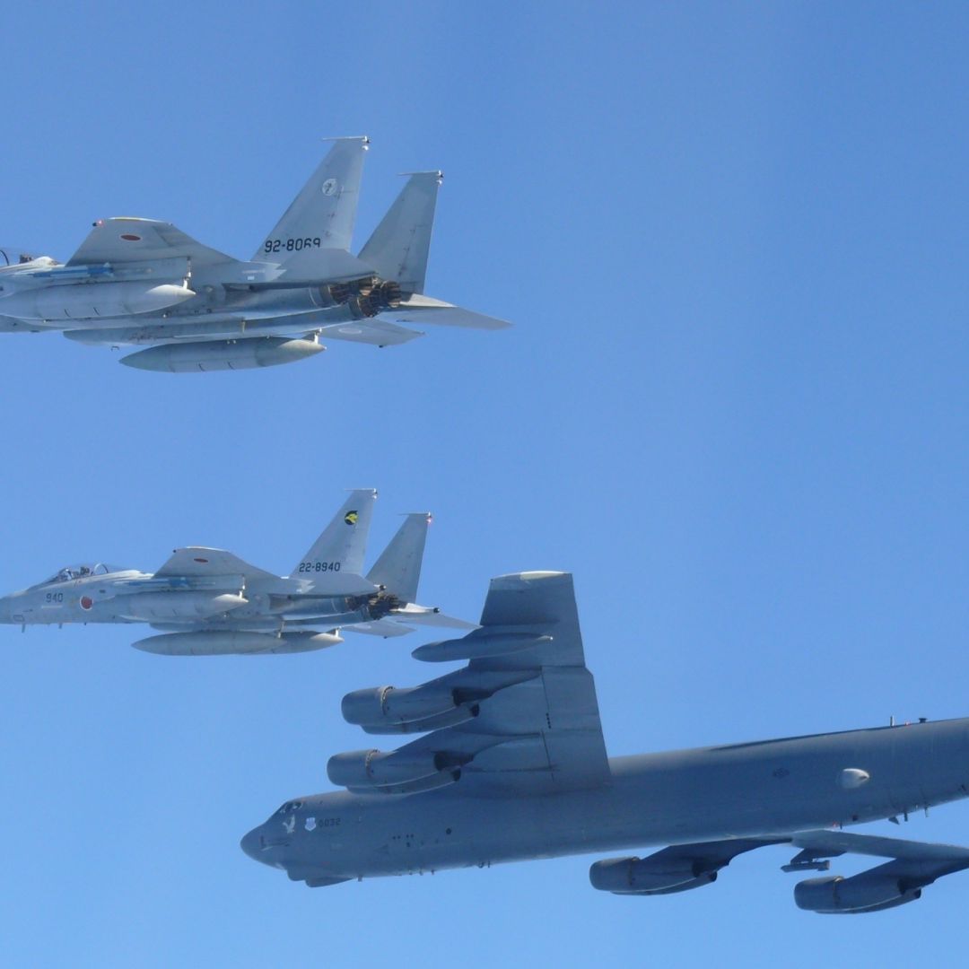 Aviones caza vuelan junto a aeronave B-52