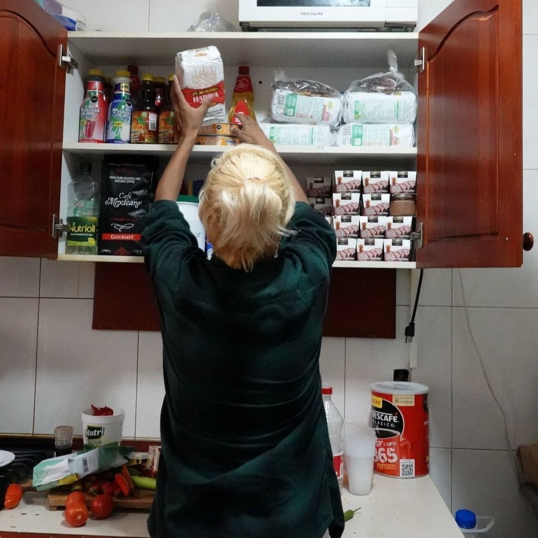 Persona acomoda productos en la despensa de una cocina
