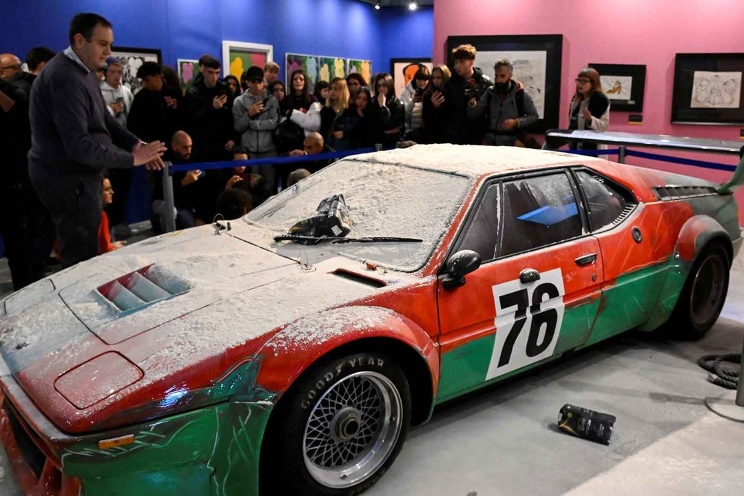Activistas medioambientales lanzan sacos de harina a un carro customizado por Andy Warhol y expuesto en Milán