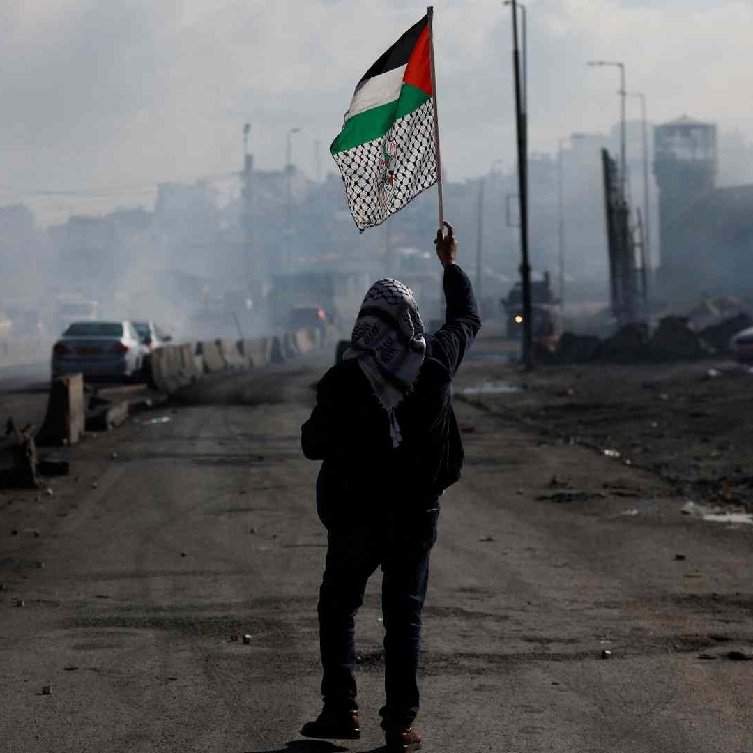 Un hombre camina con una bandera palestina