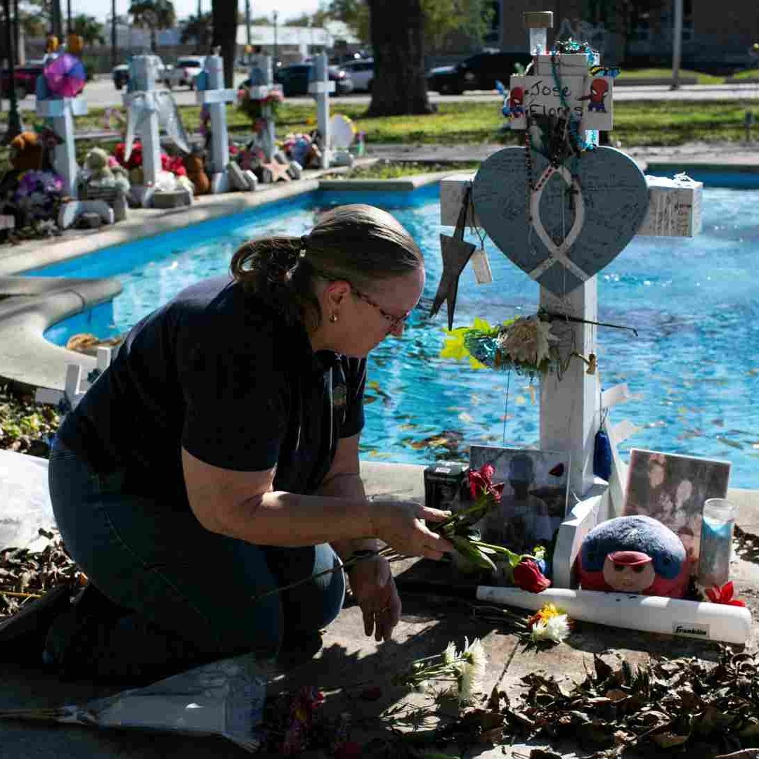 Una mujer deja unas flores en el memorial de las víctimas del tiroteo.