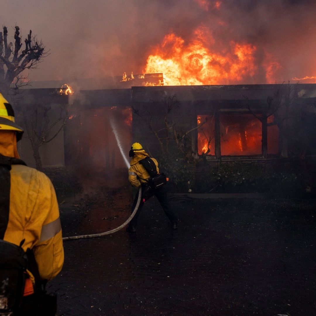 Bomberos combaten incendio en Los Ángeles, California, el cual es alimentado por los vientos de Santa Ana.