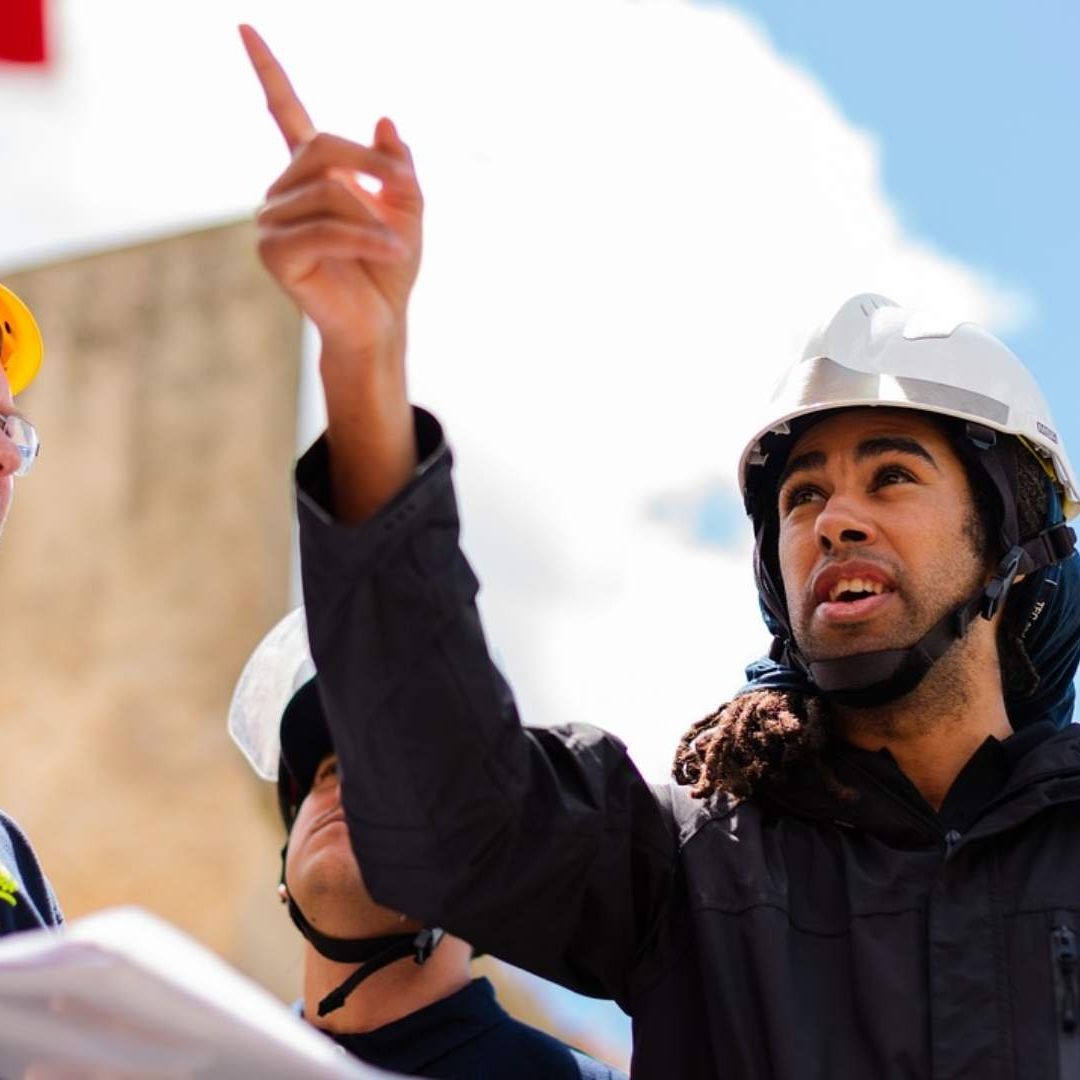 Un ingeniero da instrucciones a sus compañeros durante una construcción