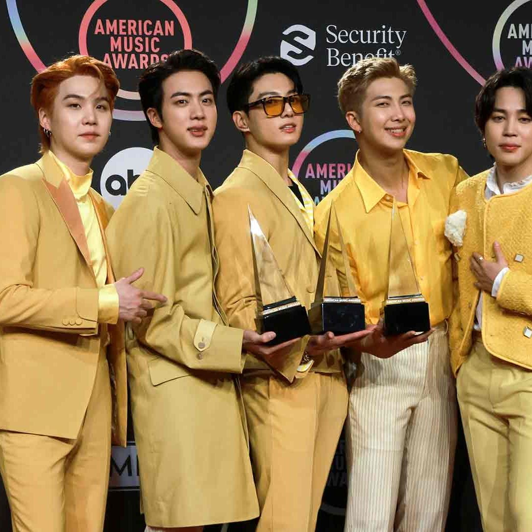 BTS sostiene varios premios mientras posan en la premiación del American Music Awards en noviembre de 2021