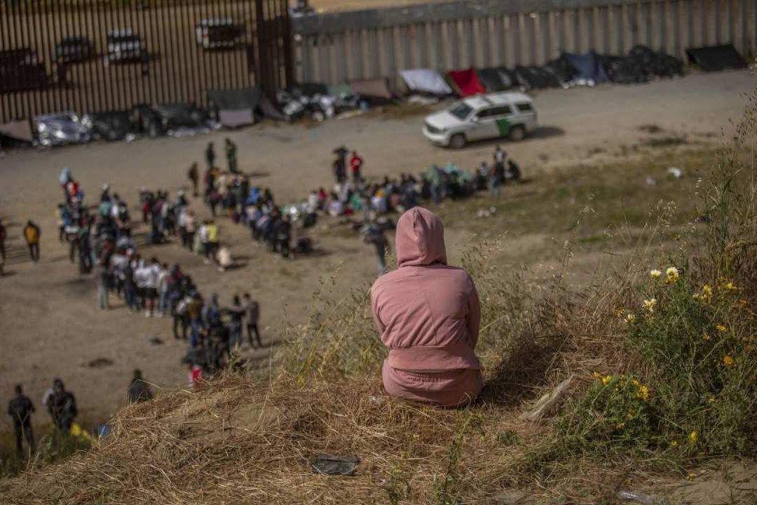 Cientos de migrantes se encuentran entre los dos muros fronterizos que dividen a Tijuana de Estados Unidos