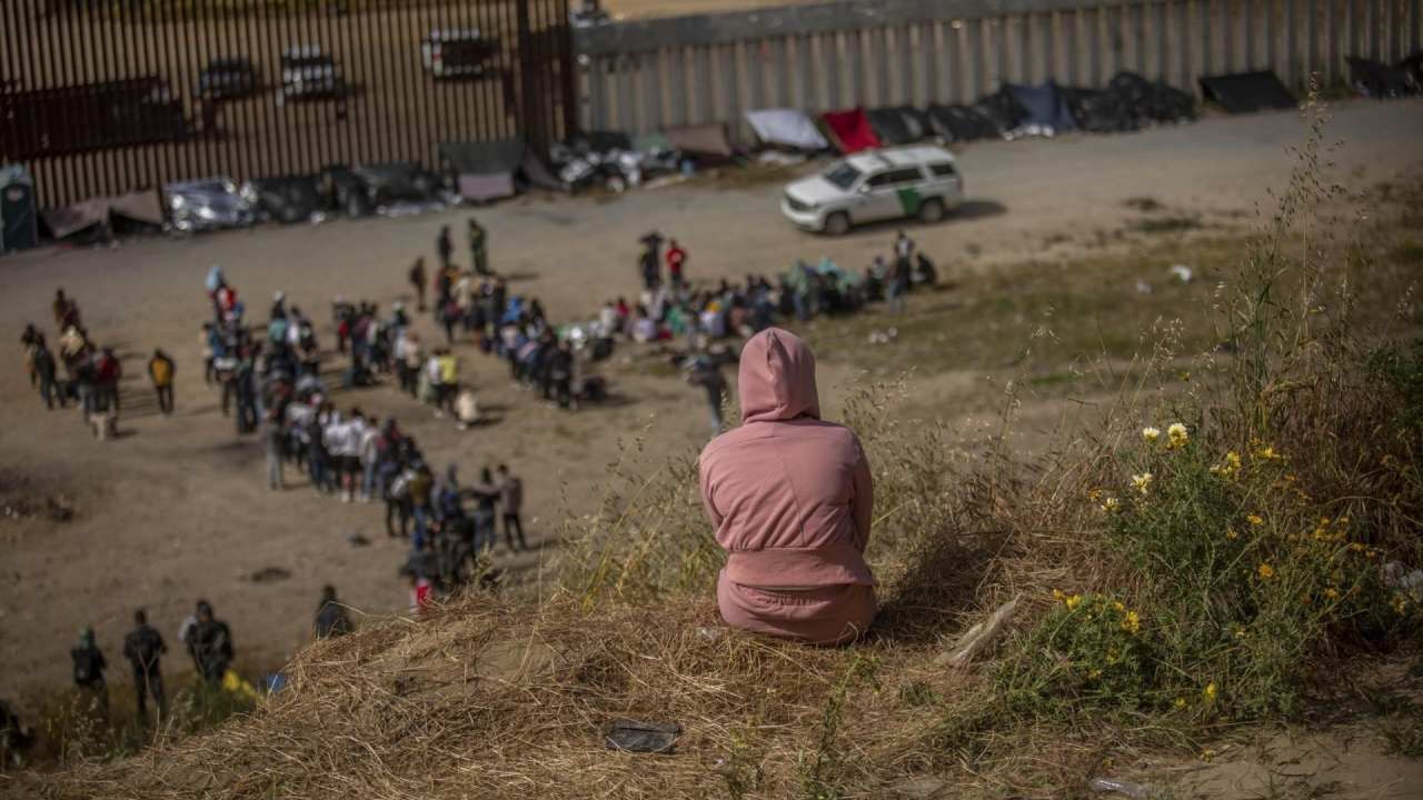 Cientos de migrantes se encuentran entre los dos muros fronterizos que dividen a Tijuana de Estados Unidos