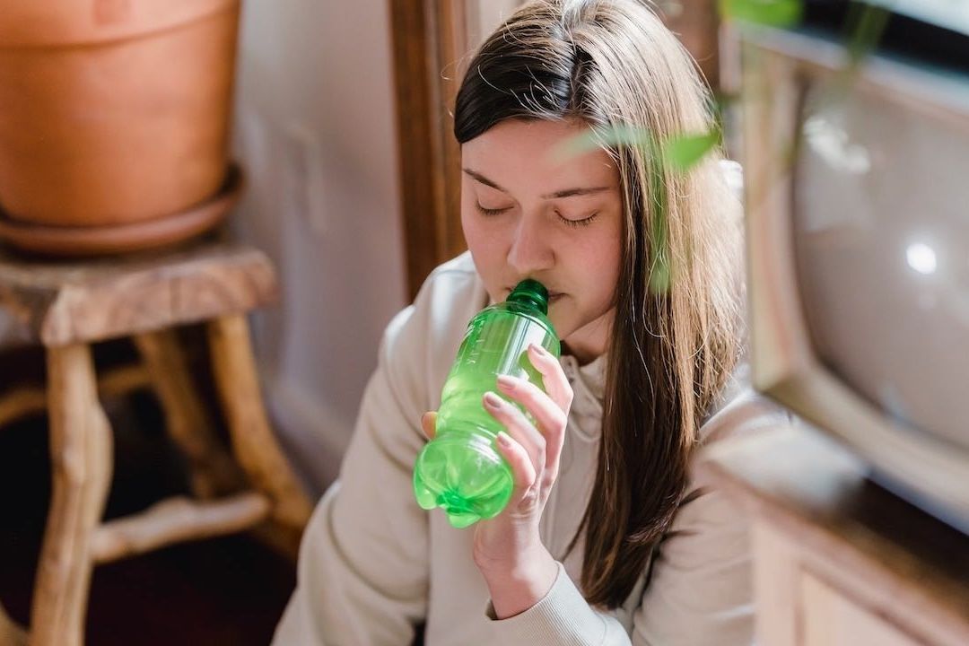 Joven toma refresco con endulzante artificial