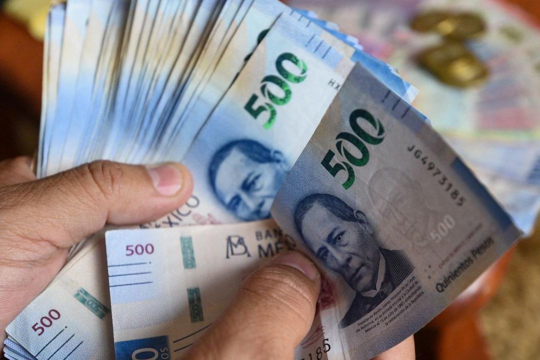 Una persona muestra su sueldo en billete de 500 pesos