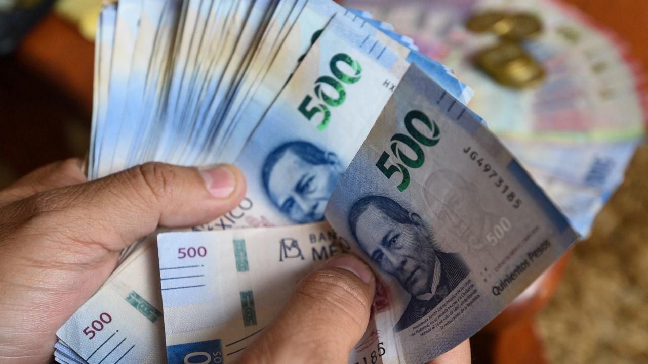 Una persona muestra su sueldo en billete de 500 pesos
