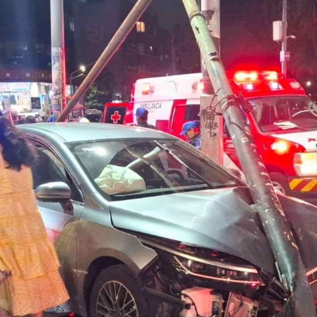 Mujer choca contra poste y semáforo.