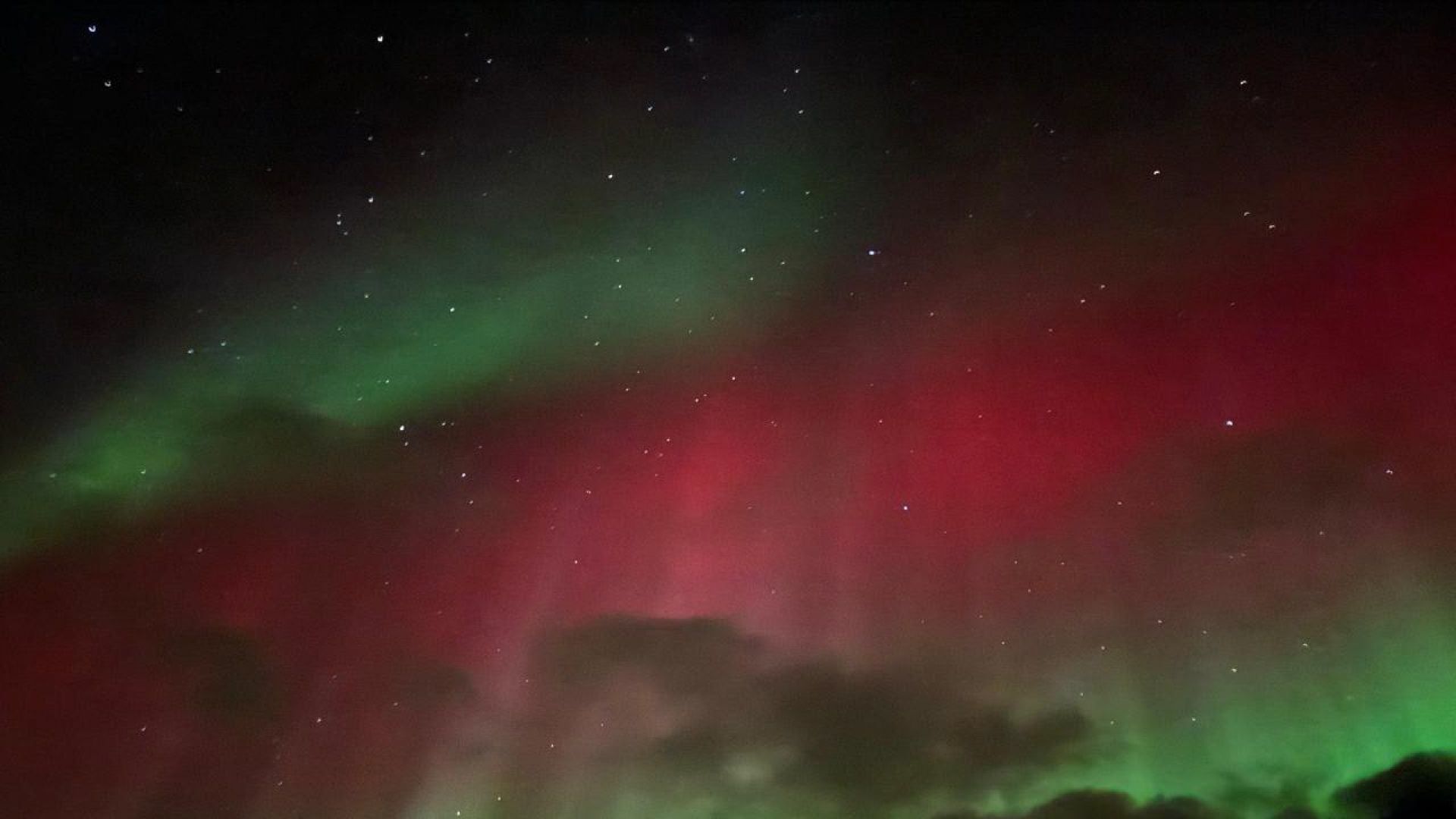 Aurora boreal con colores verde y rojo