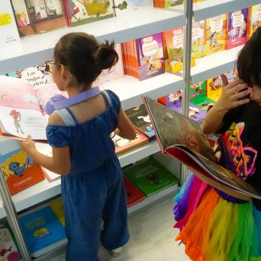 Niñas leen libros en la Feria Internacional del Libro Infantil y Juvenil (FILIJ)