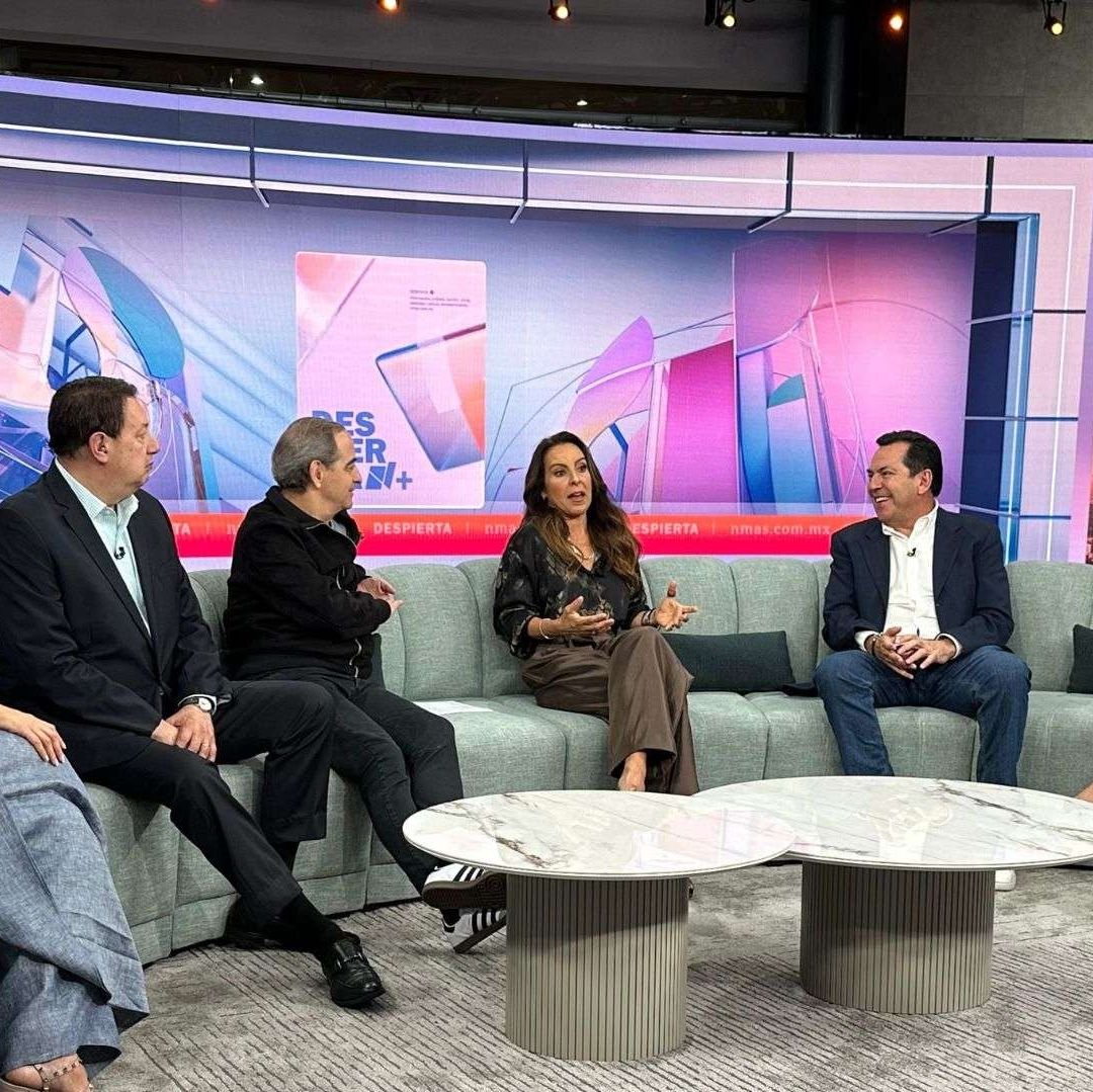 Seis personas en un foro de televisión conversan. Detrás de ellos hay pantallas.
