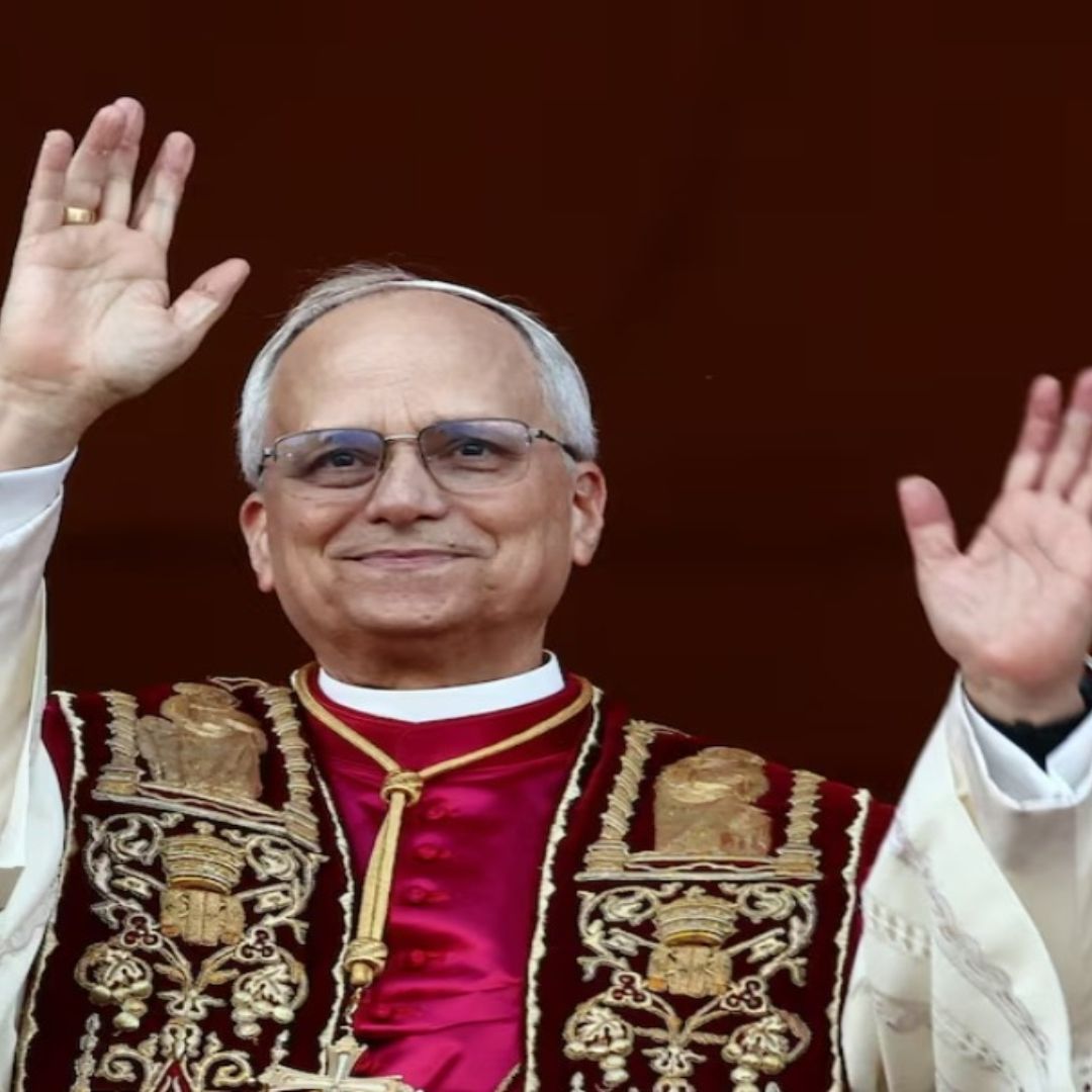 El Papa León extendiendo las manos, usa unos lentes y ropa blanca.