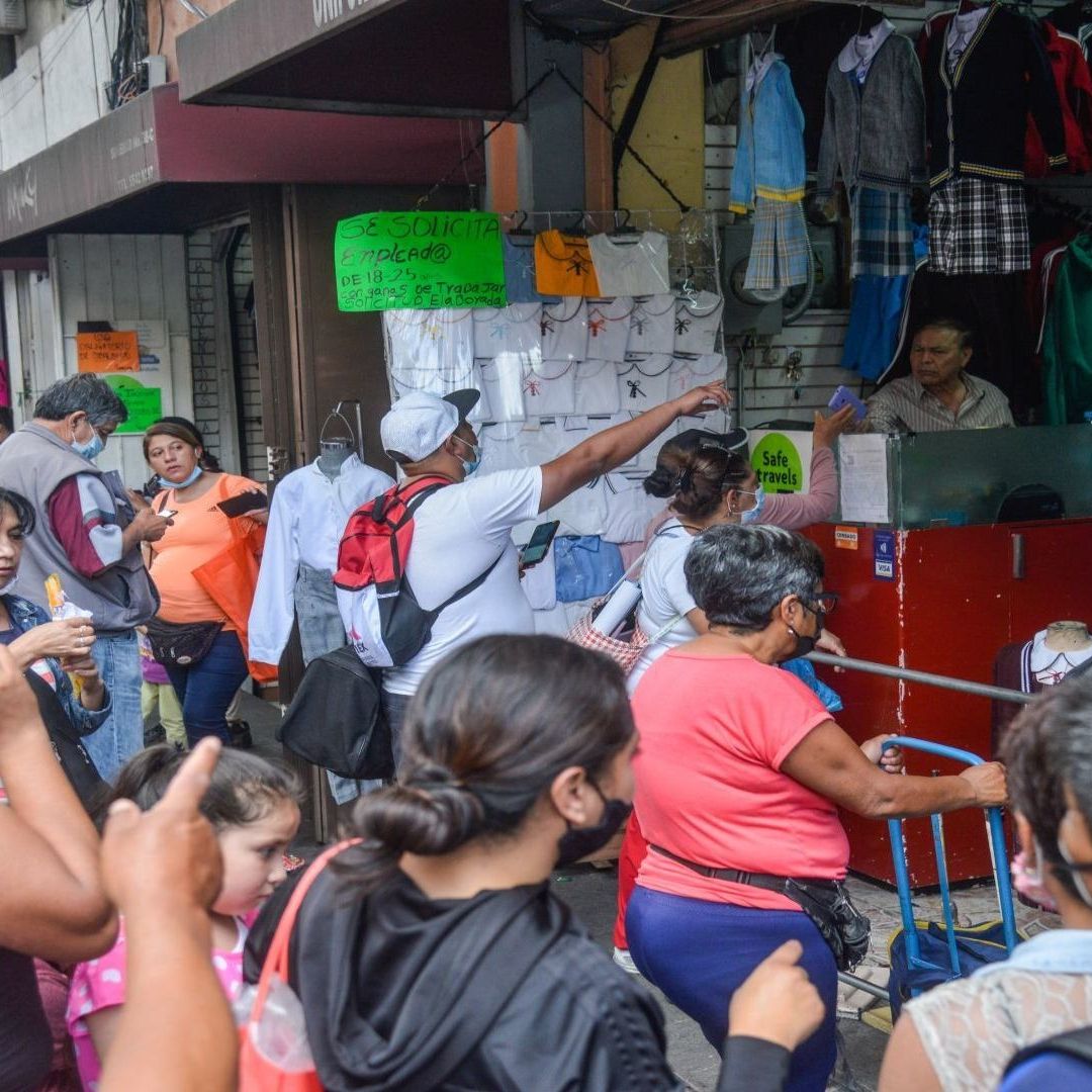 Padres de familia comprando uniformes escolares.