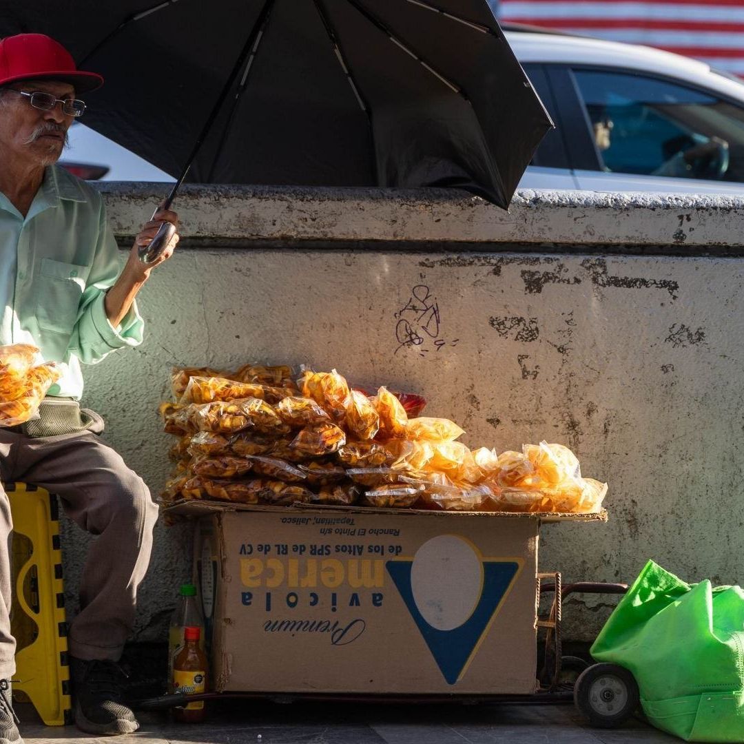 Adulto mayor junto a puesto de frituras
